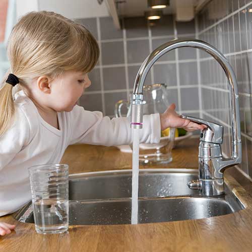 Dieťa si napúšťa čistú vodu upravenú Uvinnecom do pohára